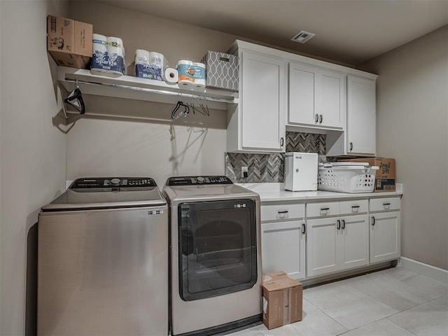 washroom with cabinets, light tile patterned flooring, and washer and dryer