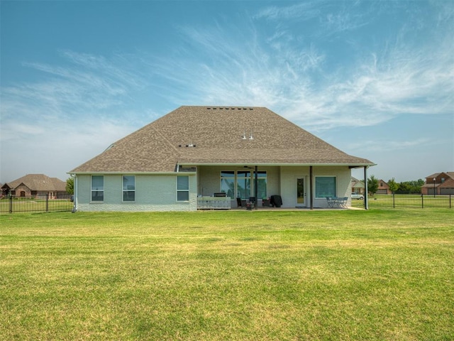 back of property with a yard and a patio area