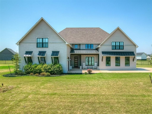 rear view of property with a yard and a patio area