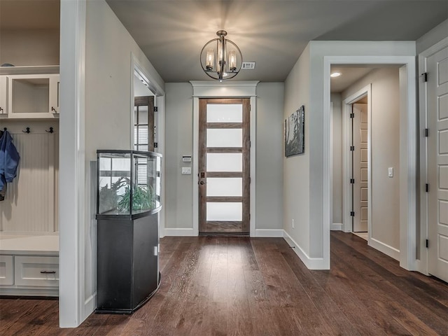 foyer entrance with dark wood-type flooring and a chandelier