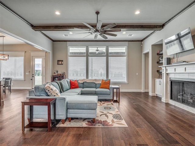 living room featuring beam ceiling, a wealth of natural light, and built in shelves