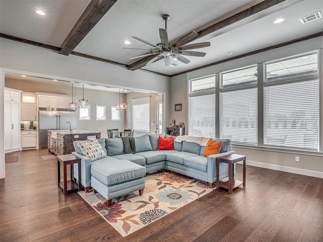 living room with crown molding, ceiling fan, beam ceiling, and dark hardwood / wood-style flooring