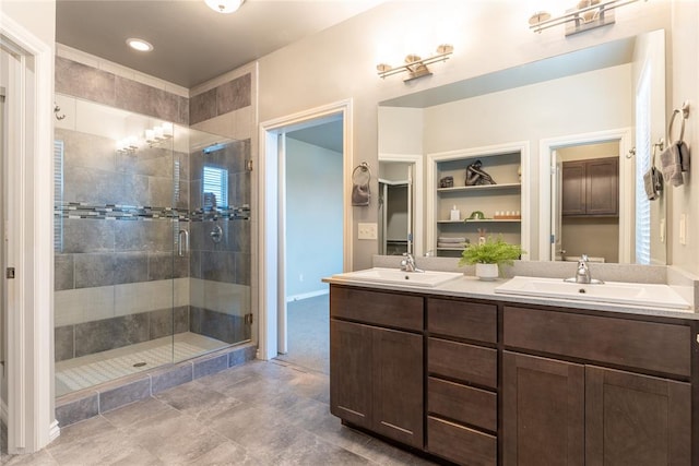 bathroom with tile patterned floors, a shower with door, and vanity