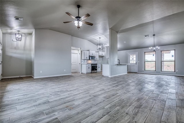 unfurnished living room featuring ceiling fan with notable chandelier, light hardwood / wood-style flooring, and lofted ceiling