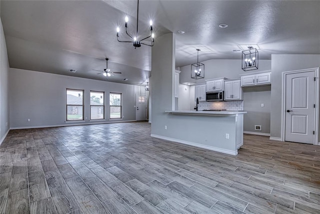 kitchen with ceiling fan, light hardwood / wood-style flooring, white cabinetry, hanging light fixtures, and lofted ceiling