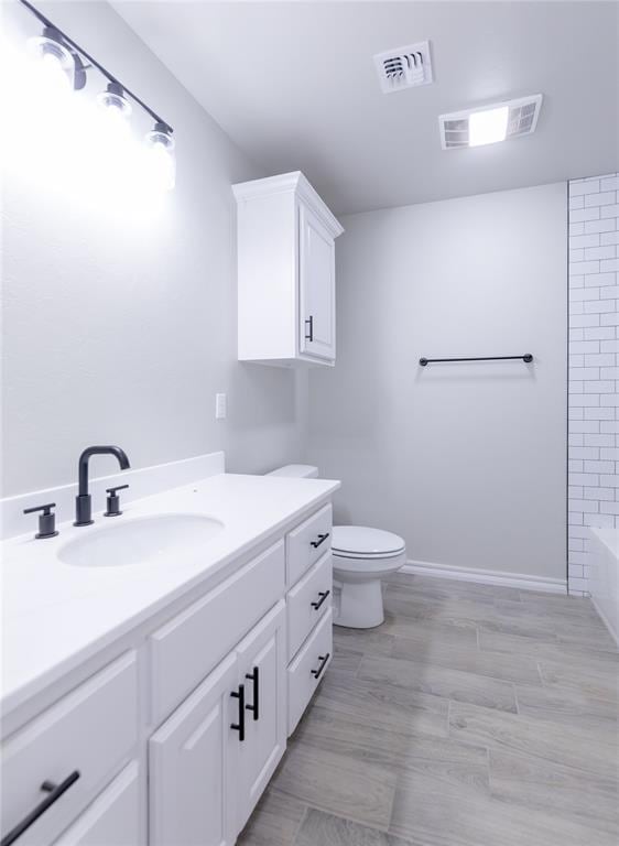 full bathroom with hardwood / wood-style floors, vanity, shower with separate bathtub, and toilet