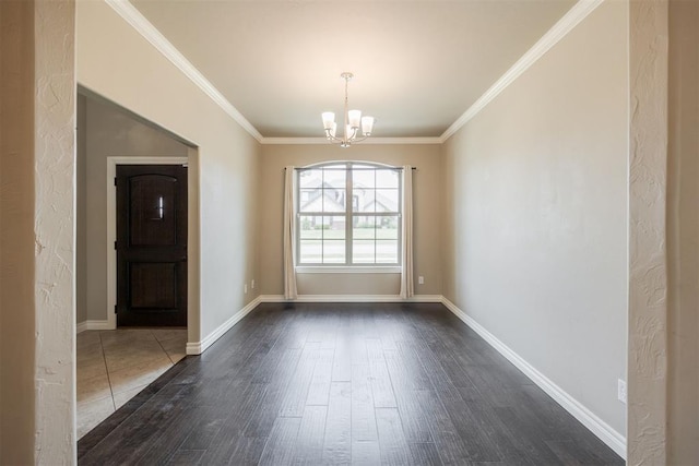 empty room featuring dark hardwood / wood-style flooring, crown molding, and a notable chandelier