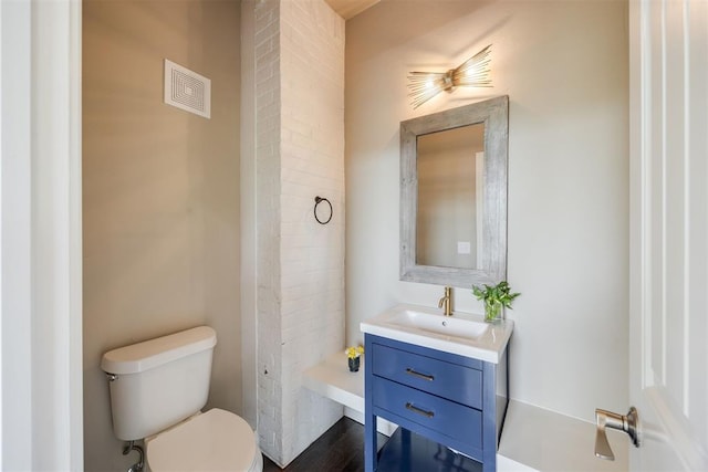 bathroom with vanity, toilet, and wood-type flooring