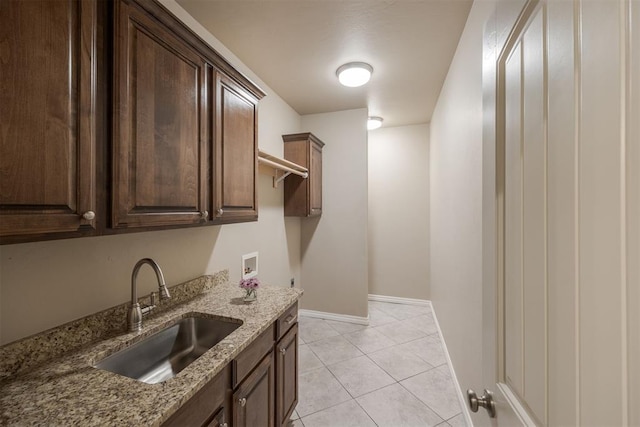 laundry area featuring cabinets, hookup for a washing machine, light tile patterned floors, and sink