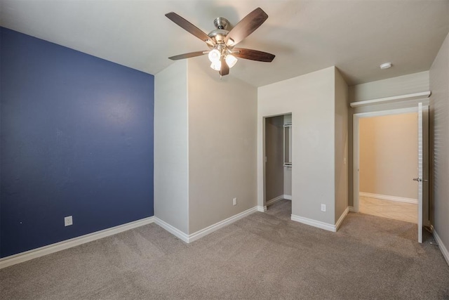 unfurnished bedroom featuring light carpet, a closet, and ceiling fan