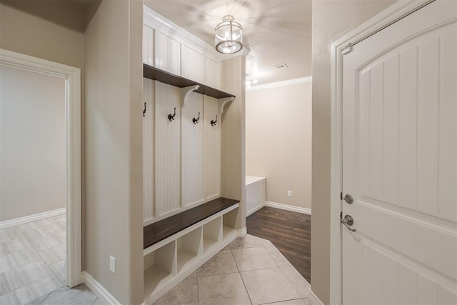 mudroom featuring crown molding, light hardwood / wood-style floors, and a notable chandelier