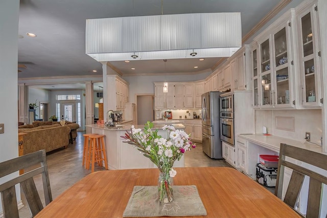 dining space with sink, french doors, and ornamental molding