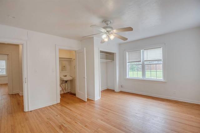 unfurnished bedroom with light wood-type flooring, a closet, ceiling fan, and sink