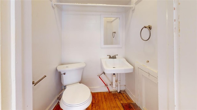 bathroom with hardwood / wood-style flooring and toilet