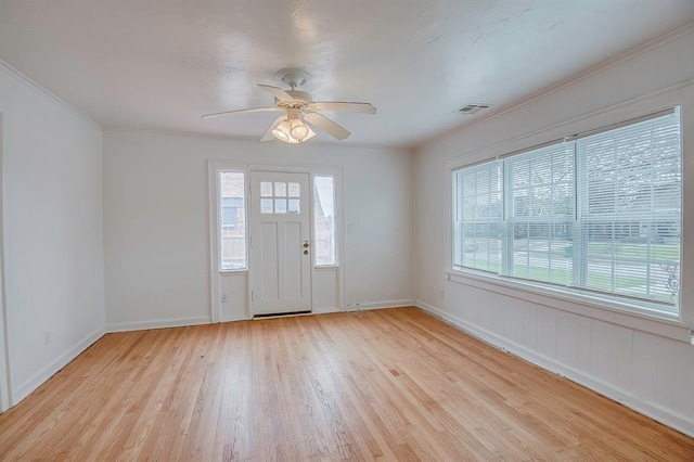 entrance foyer featuring ornamental molding, light hardwood / wood-style flooring, ceiling fan, and a healthy amount of sunlight