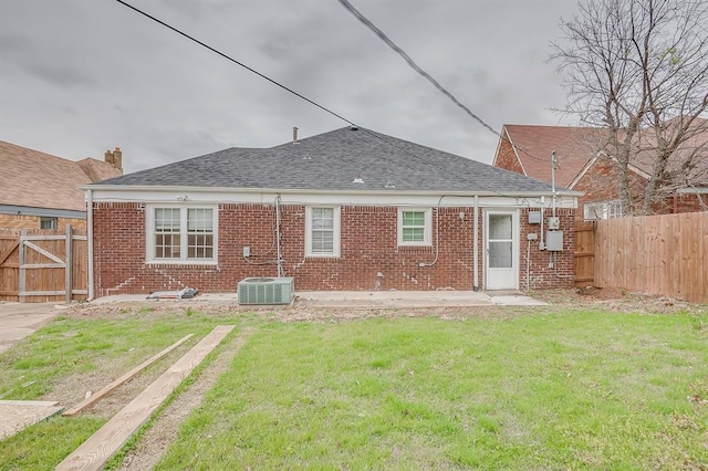 back of property with a lawn, a patio area, and central air condition unit