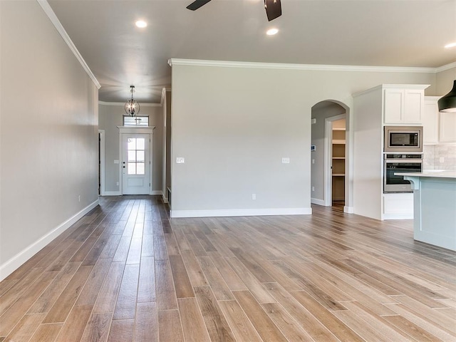 unfurnished living room featuring ceiling fan, crown molding, and light hardwood / wood-style flooring