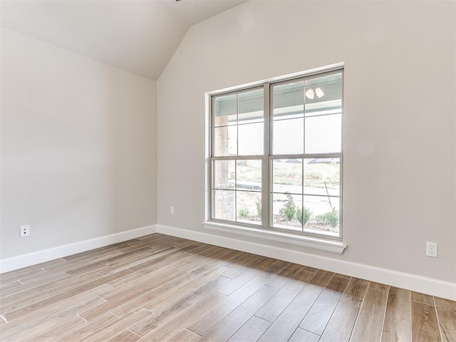 unfurnished room featuring lofted ceiling and light hardwood / wood-style flooring