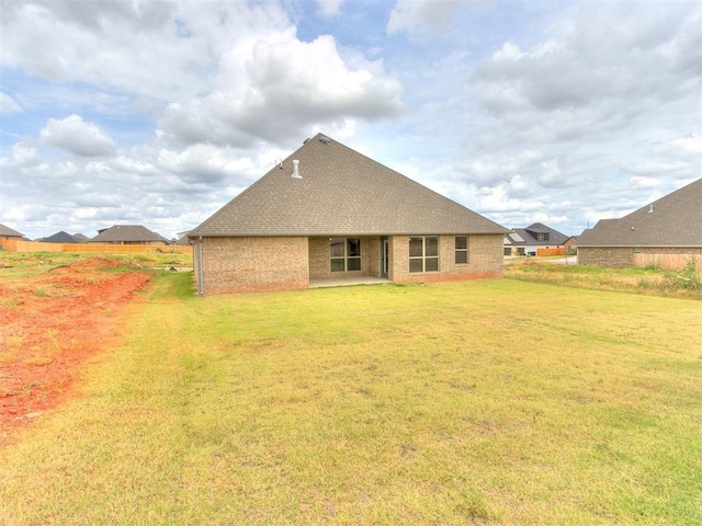 rear view of property featuring a lawn