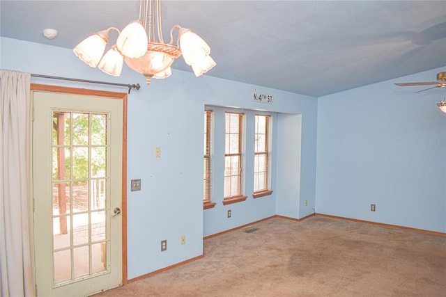 interior space with ceiling fan with notable chandelier and light colored carpet