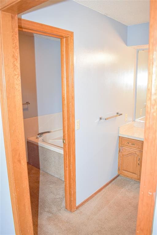 bathroom with vanity and tiled tub