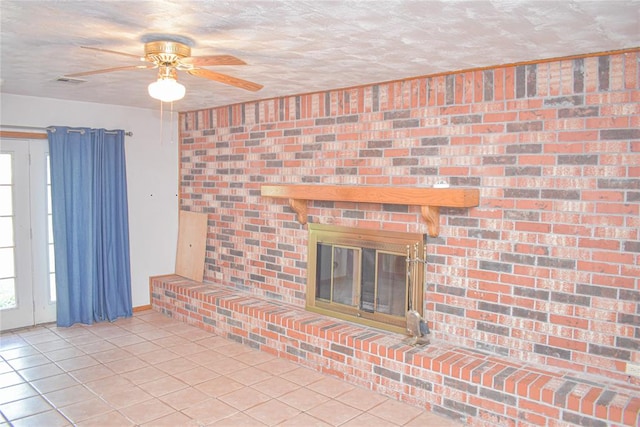 unfurnished living room featuring a fireplace, light tile patterned floors, and ceiling fan