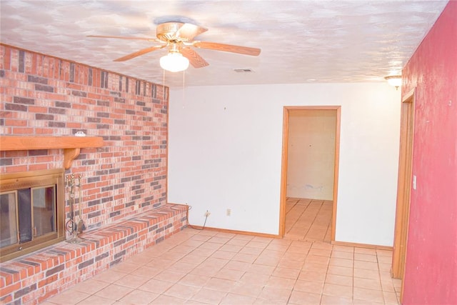 unfurnished living room featuring ceiling fan, light tile patterned floors, and a brick fireplace