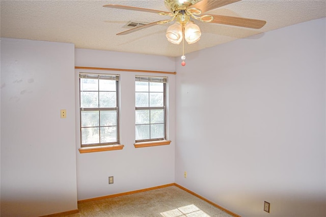 carpeted empty room featuring ceiling fan and a textured ceiling