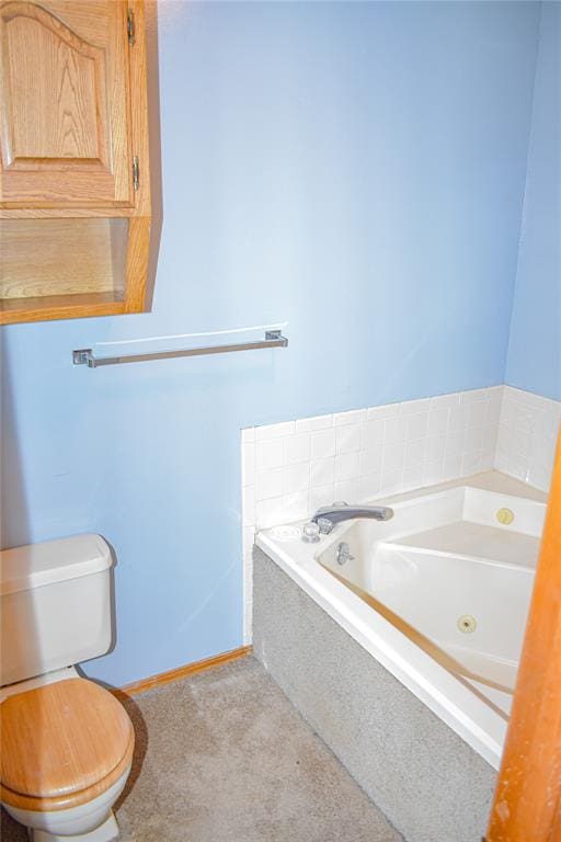 bathroom featuring tiled tub and toilet