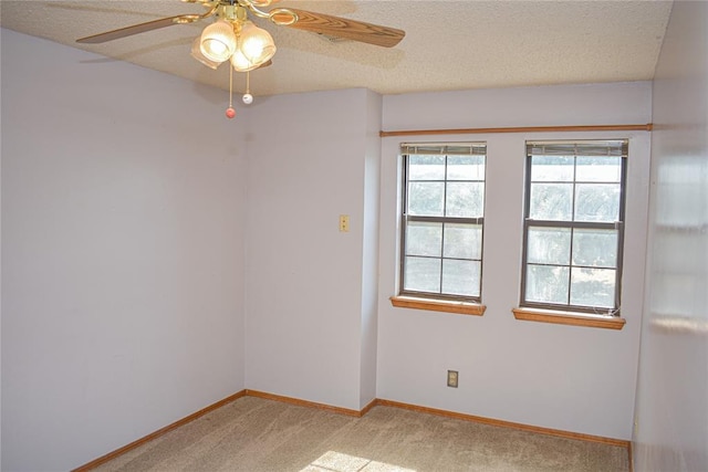 carpeted empty room with ceiling fan and a textured ceiling