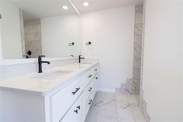 bathroom with double vanity, marble finish floor, a sink, and recessed lighting