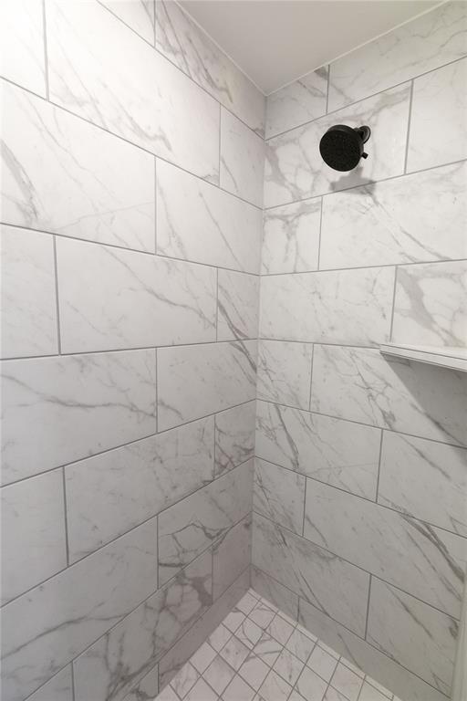 interior details featuring a tile shower