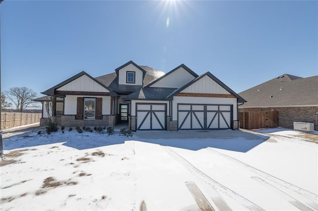 view of front facade featuring board and batten siding, an attached garage, and fence