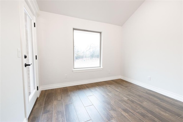 spare room featuring vaulted ceiling and dark wood-type flooring