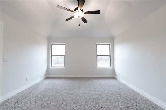 carpeted empty room with ceiling fan, vaulted ceiling, and a healthy amount of sunlight