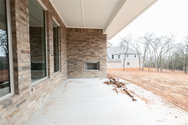 view of patio featuring an outdoor brick fireplace