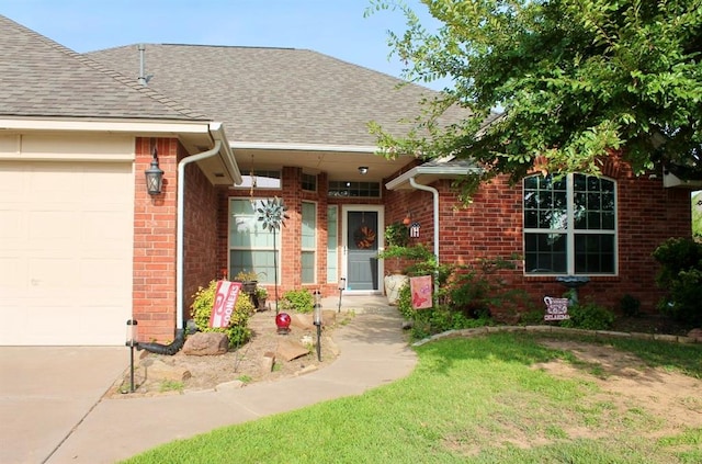 doorway to property with a garage and a yard