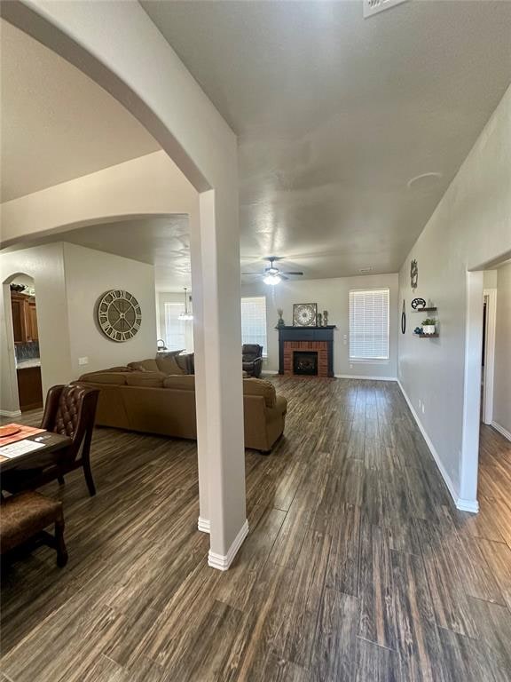 living room with ceiling fan and dark wood-type flooring