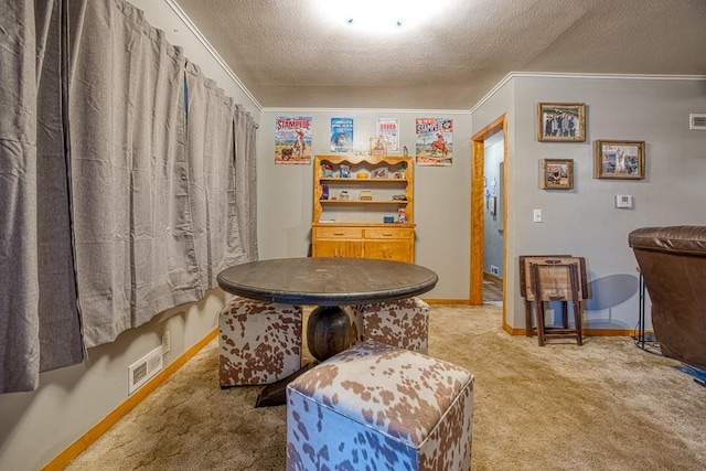 sitting room featuring a textured ceiling, ornamental molding, and carpet floors