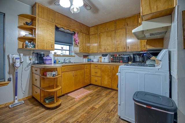 kitchen featuring sink, ceiling fan, stove, light hardwood / wood-style flooring, and backsplash