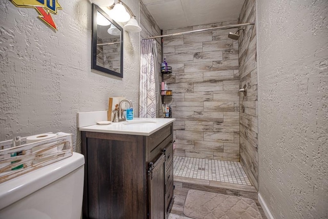 bathroom featuring toilet, vanity, and curtained shower