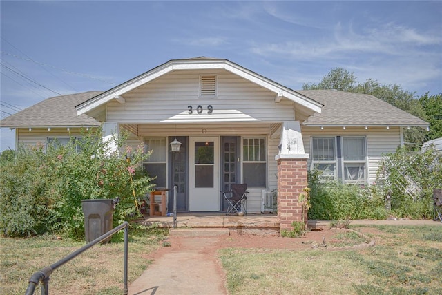 view of front of property featuring covered porch and a front lawn