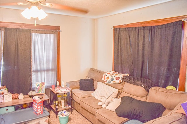 living room with ceiling fan and a textured ceiling