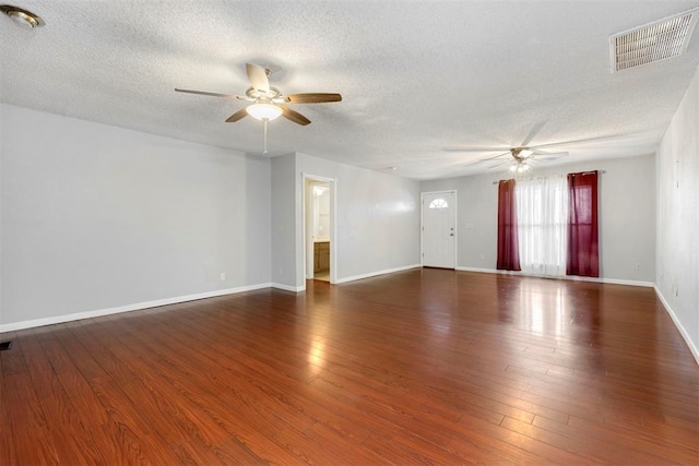 empty room featuring a textured ceiling, ceiling fan, and dark wood-type flooring