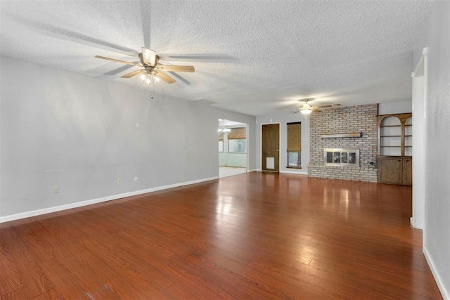 unfurnished living room featuring ceiling fan, a fireplace, wood-type flooring, and a textured ceiling