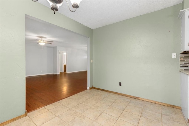 empty room featuring ceiling fan, a textured ceiling, and light hardwood / wood-style flooring