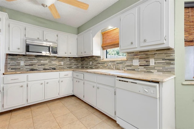 kitchen with white cabinets, decorative backsplash, sink, and white dishwasher