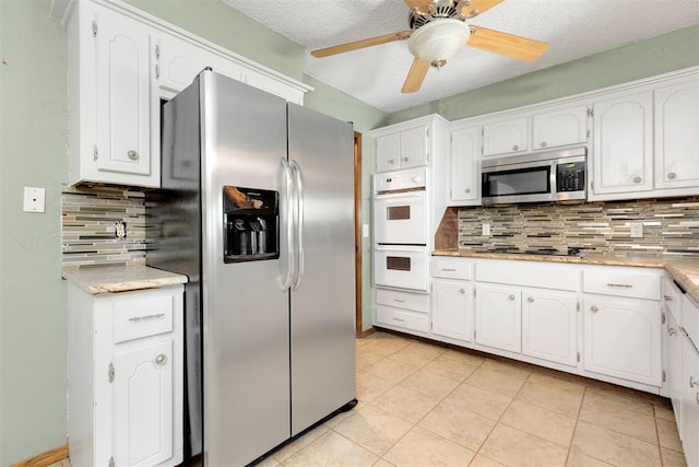 kitchen with backsplash, white cabinets, ceiling fan, a textured ceiling, and stainless steel appliances