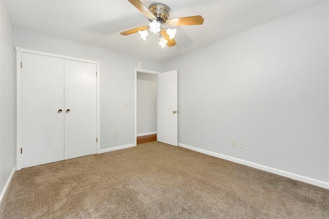 unfurnished bedroom featuring carpet flooring, ceiling fan, a closet, and a textured ceiling