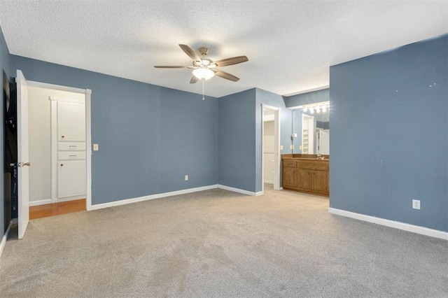 carpeted spare room with a textured ceiling and ceiling fan